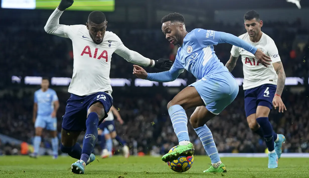 Penyerang Manchester City Raheem Sterling berebut bola dengan bek Tottenham Hotspur Emerson Royal pada pekan ke-26 Liga Inggris di Etihad stadium, Minggu (20/2/2022) dinihari WIB. Manchester City takluk 2-3 dari tim tamu, Tottenham Hotspur.  (AP Photo/Jon Super)