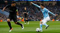 Gelandang Manchester City, David Silva (kanan) berusaha melewati bek PSG, Thiago Silva di leg kedua liga Champions di Etihad Stadium, Inggris (13/4). City menang atas PSG dengan skor 1-0. (Reuters/Jason Cairnduff)