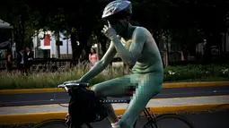 Seorang pria mengendarai sepeda dengan tubuh di cat serta telanjang saat mengikuti World Naked Bike Ride di Guadalajara, Jalisco, Meksiko (17/6). Acara ini digelar untuk memprotes polusi gas emisi dari mobil. (AFP Photo/Hector Guerrero)