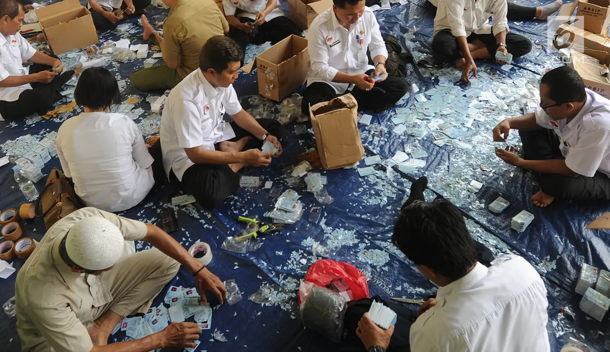 Pegawai  Negeri Sipil (PNS) di lingkungan Kemendagri menggunting E-KTP untuk dihancurkan di Gundang Kemendagri, Bogor (30/5). Sekitar seratus PNS dilibatkan selama sepuluh hari untuk menghancurkan lebih dari 800 ribu E-KTP. (Merdeka.com/Arie Basuki)