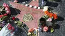 Karangan bunga diletakkan di trotoar dekat prasasti Debbie Reynolds di Hollywood Walk of Fame Star, Kamis (29/12). (AP Photo / Reed Saxon)