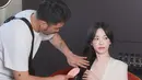 Dalam salah satu momen behind the scenes, Song Hye Kyo terlihat sedang melakukan touch-up rambut sambil memegang botol parfum Guerlain. Rambut hitam panjangnya ditata dalam gelombang lembut yang membingkai wajah, semakin menonjolkan aura klasik yang menjadi ciri khasnya. [Dok/@kyo1122].