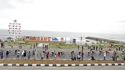 Para pebalap melintaspantai Padang pada etape ke-8 Tour de Singkarak 2016 di Kota Padang, Sumatera Barat, Minggu (14/8/2016). (Bola.com/Nicklas Hanoatubun)