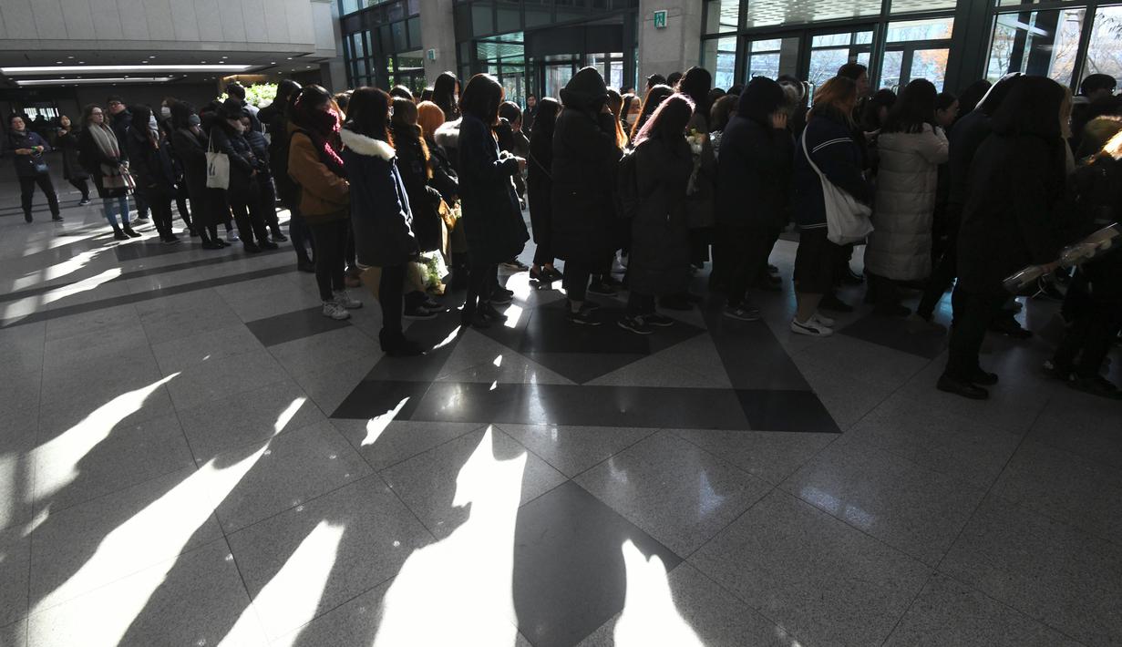 Para fans memberikan penghormatan kepada Jonghyun SHINee di rumah duka Seoul Asan Hospital, Korea Selatan, Selasa (19/12). Diungkapkan, para member SHINee yang lain akan menjadi pengiring peti mendiang Jonghyun. (JUNG Yeon-Je / AFP)