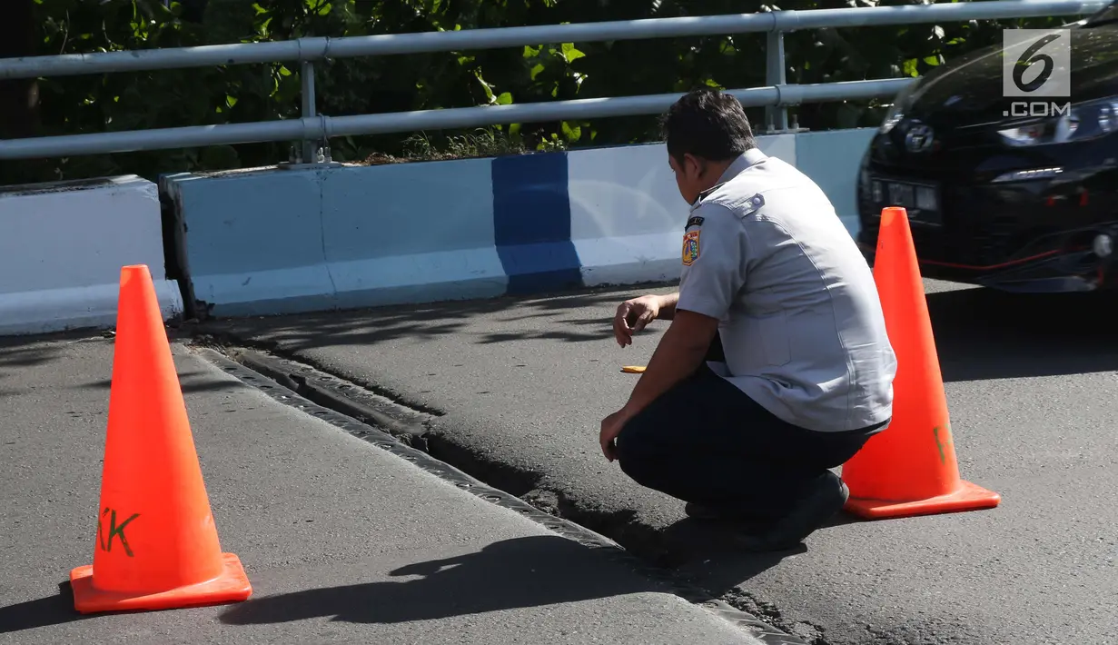 Petugas Dishub DKI Jakarta mengecek kondisi salah satu ruas jalan layang yang retak di kawasan Kemayoran, Jakarta, Kamis (3/1). Akibat retakan ini, para pengendara harus lebih berhati-hati saat melintas. (Liputan6.com/Helmi Fithriansyah)