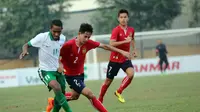 Pemain sayap Timnas U-19, Pandi Lestaluhu berebut bola dengan pemain Laos dalam laga yang berakhir dengan skor 3-1 di Vietnam Youth Training Center, Hanoi, Minggu (18/9/2016). (PSSI)