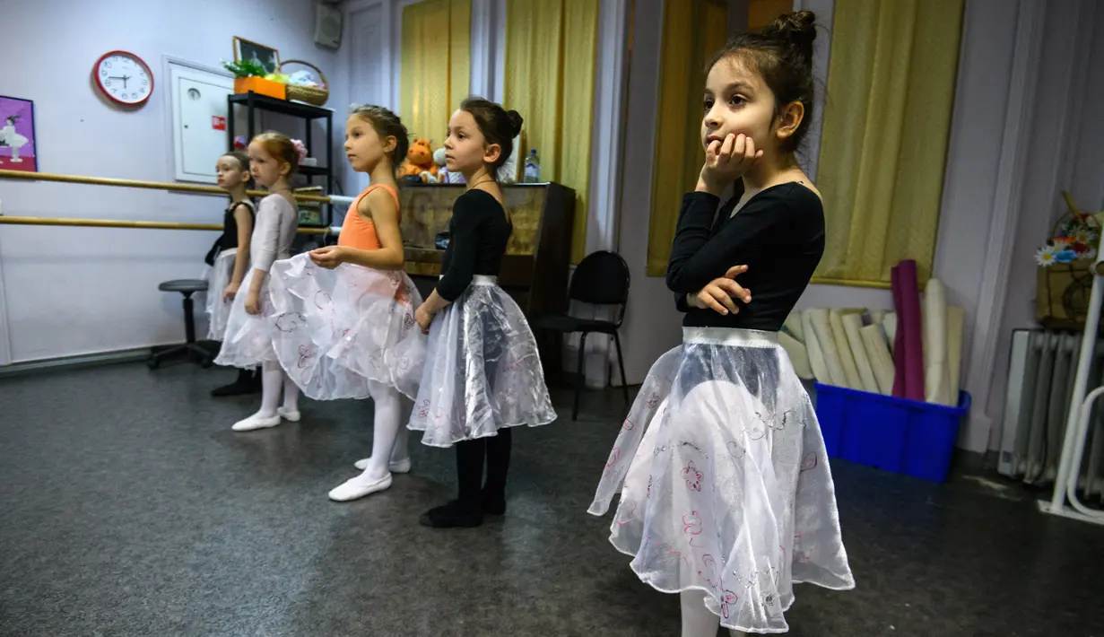 Gadis-gadis kecil mengikuti kelas balet di sebuah studio di Moskow , 22 November 2018. Orang tua dan kakek-nenek duduk di koridor sebuah studio kecil di Moskow utara menunggu anak-anak usia tiga tahun menyelesaikan kelas balet mereka. (Mladen ANTONOV/AFP)