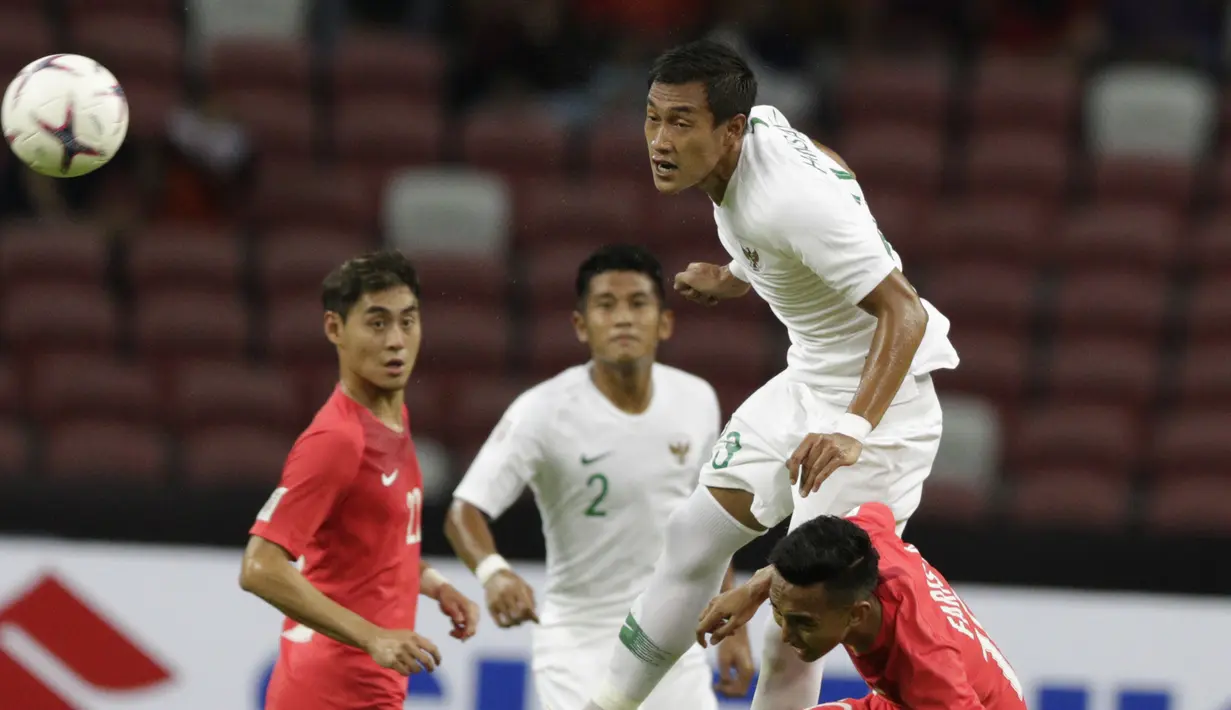 Kapten Indonesia, Hansamu Yama, menyundul bola saat melawan Singapura pada laga Piala AFF di Stadion Nasional, Singapura, Jumat (9/11). Indonesia menang atas Singapura. (Bola.com/M Iqbal Ichsan)