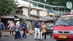 Pejalan kaki menyeberangi jalan di depan Stasiun Lenteng Agung, Jakarta, Senin (4/11/2019). Meski telah tersedia JPO, sebagian pejalan kaki lebih memilih untuk menyeberang sembarangan sehingga mengganggu arus lalu lintas serta berpotensi menimbulkan kecelakaan. (Liputan6.com/Immanuel Antonius)