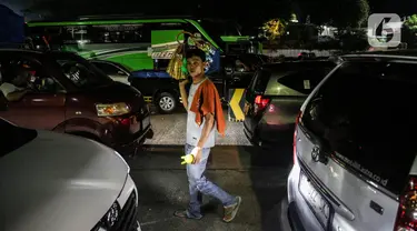 Seorang pedagang asongan menjajakan dagangannya di Pelabuhan Merak, Kota Cilegon, Banten, Rabu (19/4/2023). (Liputan6.com/Faizal Fanani)