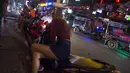 Foto pada 11 Oktober 2018 menunjukkan sejumlah wanita berkumpul di trotoar Nana Red Light Distrik, Bangkok, Thailand. Nana Red Light District memang dikenal sebagai kawasan hiburan malam terbesar di Bangkok. (Romeo GACAD / AFP)