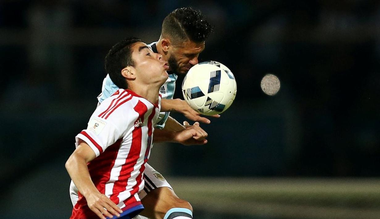 Duel antara pemain Argentina, Martin Demichelis, dan pemain Paraguay, Miguel Almiron, dalam laga Kualifikasi Piala Dunia 2018 zona Amerika Selatan, di Stadion Mario Kempes, Cordoba, Rabu (12/10/2016) pagi WIB. (Reuters/Marcos Brindicci)