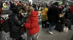 Dua orang memegang perangkat seluler setelah kedatangan kereta dengan pengungsi Ukraina di stasiun utama di Berlin, Jerman, Selasa  (1/3/2022). Menjelang malam, diperkirakan 300 orang tiba di Berlin dengan kereta api. Sejumlah relawan kemudian merawat orang-orang yang terdampar. (AP Photo/Michael So