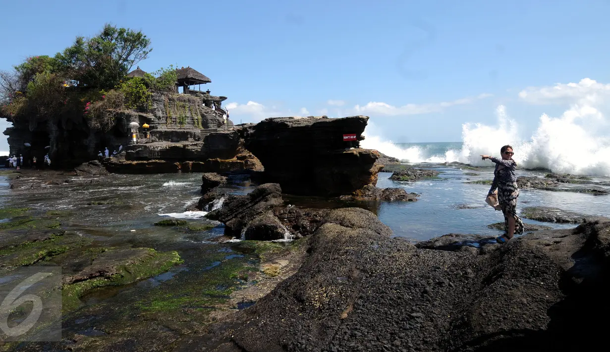 Seorang wisatawan melintas menuju salah satu bangunan pura yang ada di Tanah Lot, Bali, 31 Agustus 2015. Kawasan wisata Tanah Lot masih menjadi primadona bagi wisatawan yang berkunjung ke Bali. (Liputan6.com/Helmi Fithriansyah)
