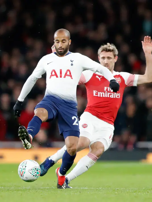Pemain Tottenham Hotspur,  Lucas Moura berebut bola dengan  pemain Arsenal, Nacho Monreal pada perempat final Piala Liga Inggris di Stadion Emirates, Kamis (20/12). Tottenham melaju ke babak semifinal seusai menaklukkan Arsenal 2-0. (AP/Frank Augstein)