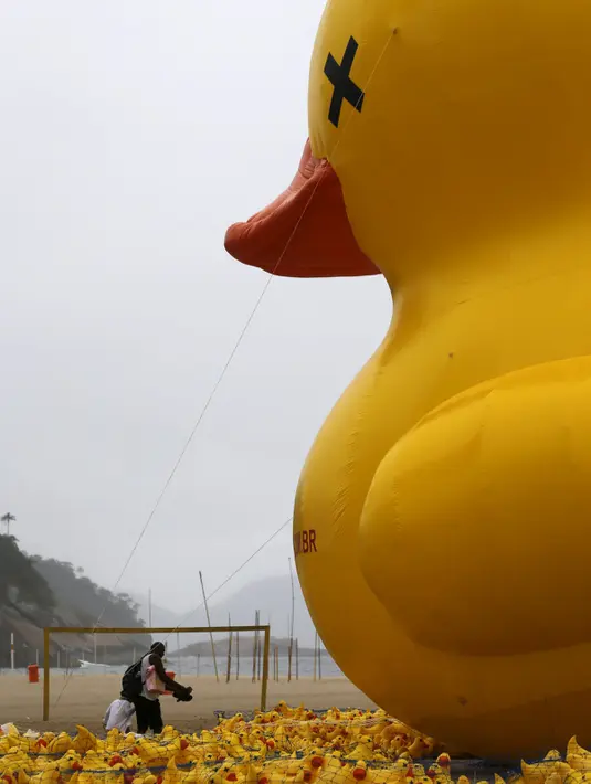 Balon raksasa berbentuk bebek terlihat di pantai Copacabana, Brasil, Minggu (25/10). Kampanye "I will not pay the Duck" ini diselenggarakan oleh Federasi Industri Rio de Janeiro ini mengacu pada industri yang membayar pajak tinggi. (REUTERS/Sergio Moraes)