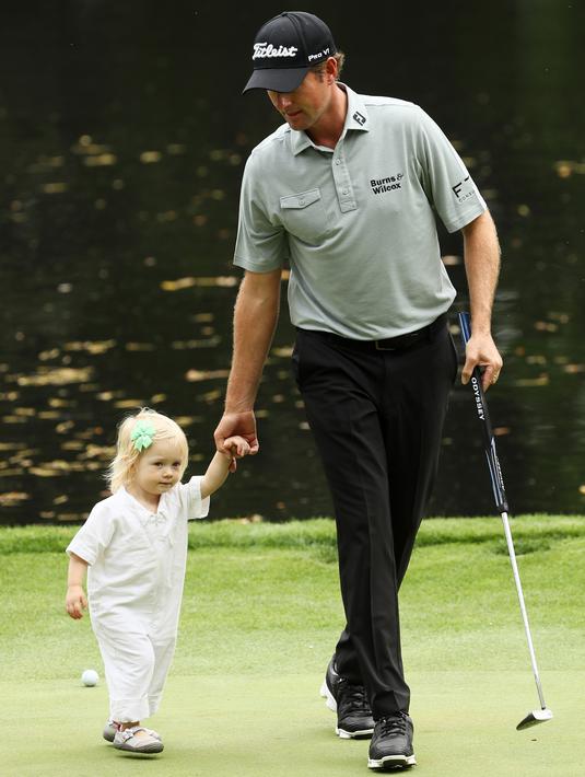 Pegolf Amerika Serikat, Webb Simpson membawa serta putrinya, Willow Grace Simpson pada hari terakhir mengikuti latihan untuk turnamen golf Masters 2018 di Augusta, Georgia, Rabu (4/4). (JAMIE Squire / Getty Images / AFP)