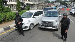 Aparat kepolisian bersenjata laras panjang melakukan pengamanan di ruas jalan menuju Puncak di Tanjakan Selarong, Bogor, Kamis (6/6/2019). Memasuki lebaran hari kedua, beberapa titik di kawasan Puncak mengalami kemacetan akibat tingginya tingkat kunjungan wisatawan domestik (merdeka.com/Arie Basuki)