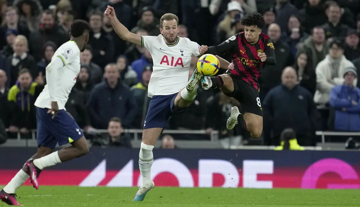 Pemain Tottenham Hotspur, Harry Kane (kiri kedua) berebut bola dengan pemain Manchester City, Ilkay Gundogan pada laga pekan ke-22 Liga Inggris 2022/2023 di Tottenham Hotspur Stadium, London, Minggu (05/02/2023) malam WIB. Laga berakhir dengan kemenangan 1-0 Tottenham Hotspur. (AP Photo/King Cheung)