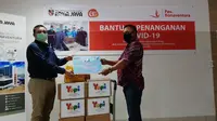 Manager Umum RS. Atma Jaya Mardiansyah (kiri) secara simbolis   menerima APD dari Yupi yang diwakili Assistant Promotion Manager Yupi Indo Jelly Gum Tri Pantja Djaya di RS Atma Jaya, Pluit,  Jakarta (15/6/20). foto: dok. Yupi