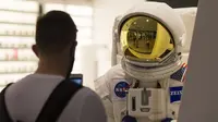 Seorang pelanggan yang mengenakan masker mengabadikan foto pakaian luar angkasa di CF Toronto Eaton Center, Toronto, Kanada, 6 Oktober 2020. Hingga Selasa (6/10/2020) sore waktu setempat, Kanada melaporkan 170.945 kasus COVID-19 termasuk 9.527 kematian. (Xinhua/Zou Zheng)