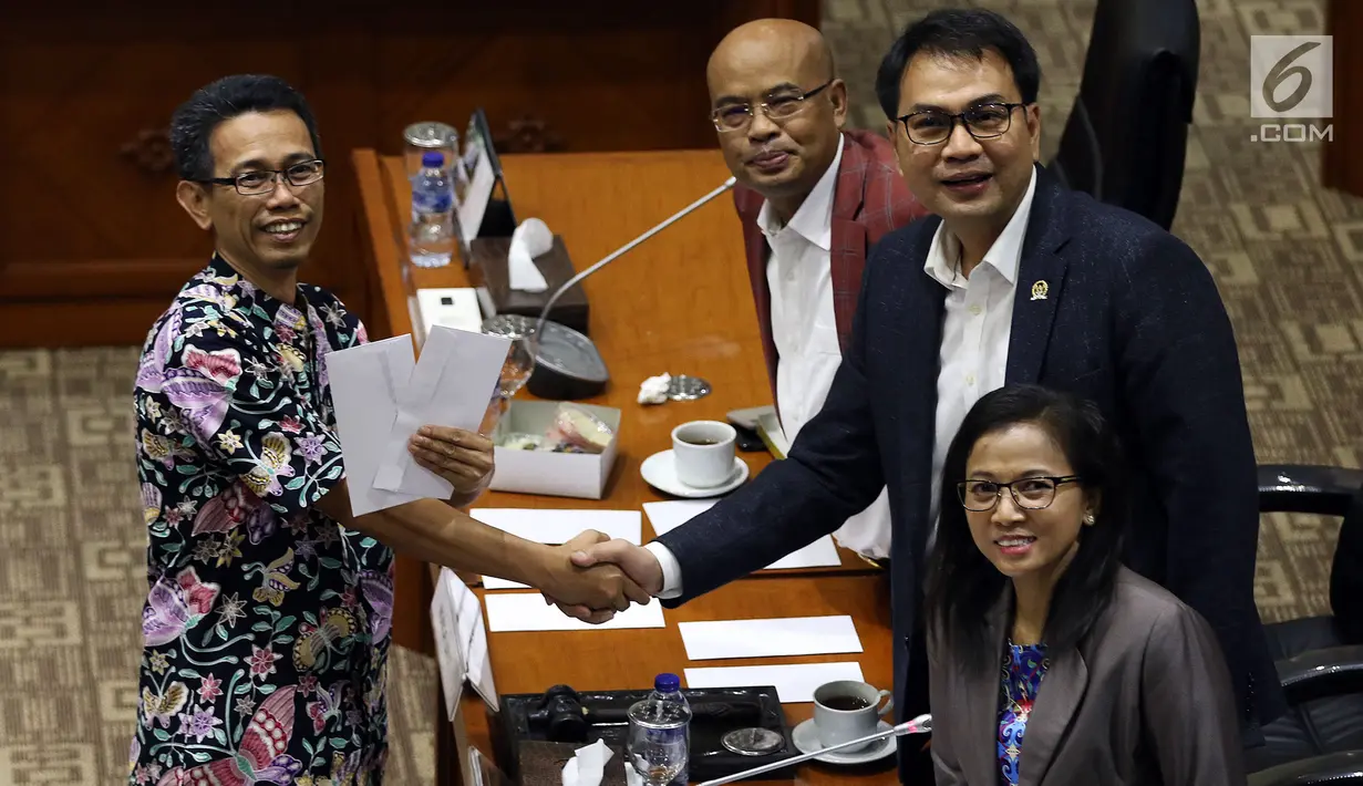Calon Pimpinan KPK Luthfi Jayadi berjabat tangan dengan Ketua Komisi III DPR Aziz Syamsuddin (kanan) usai menerima amplop berisi tema makalah yang harus dibuat, saat uji kelayakan dan kepatutan capim KPK di Kompleks Parlemen, Senayan, Jakarta, Senin (9/9/2019). (Liputan6.com/Johan Tallo)