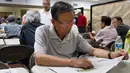 Seorang pria membaca koran di pusat Layanan Komunitas Korea di New York (10/8). Sekitar 100.000 orang Korea tinggal di New York City (10/8).  (AFP Photo/Don Emmert/To Go With AFP STORY by Jennie Matthew, NKorea-US-nuclear-diaspora)