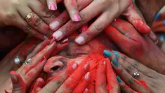 Wajah seorang siswa dilumurkan bubuk warna saat perayaan Holi di Kolkata, India (7/3). Holi atau Festival Warna adalah festival awal musim semi yang dirayakan di India, Nepal, Bangladesh, dan negara-negara yang mayoritas beragama Hindu. (AFP/Dibyangshu)