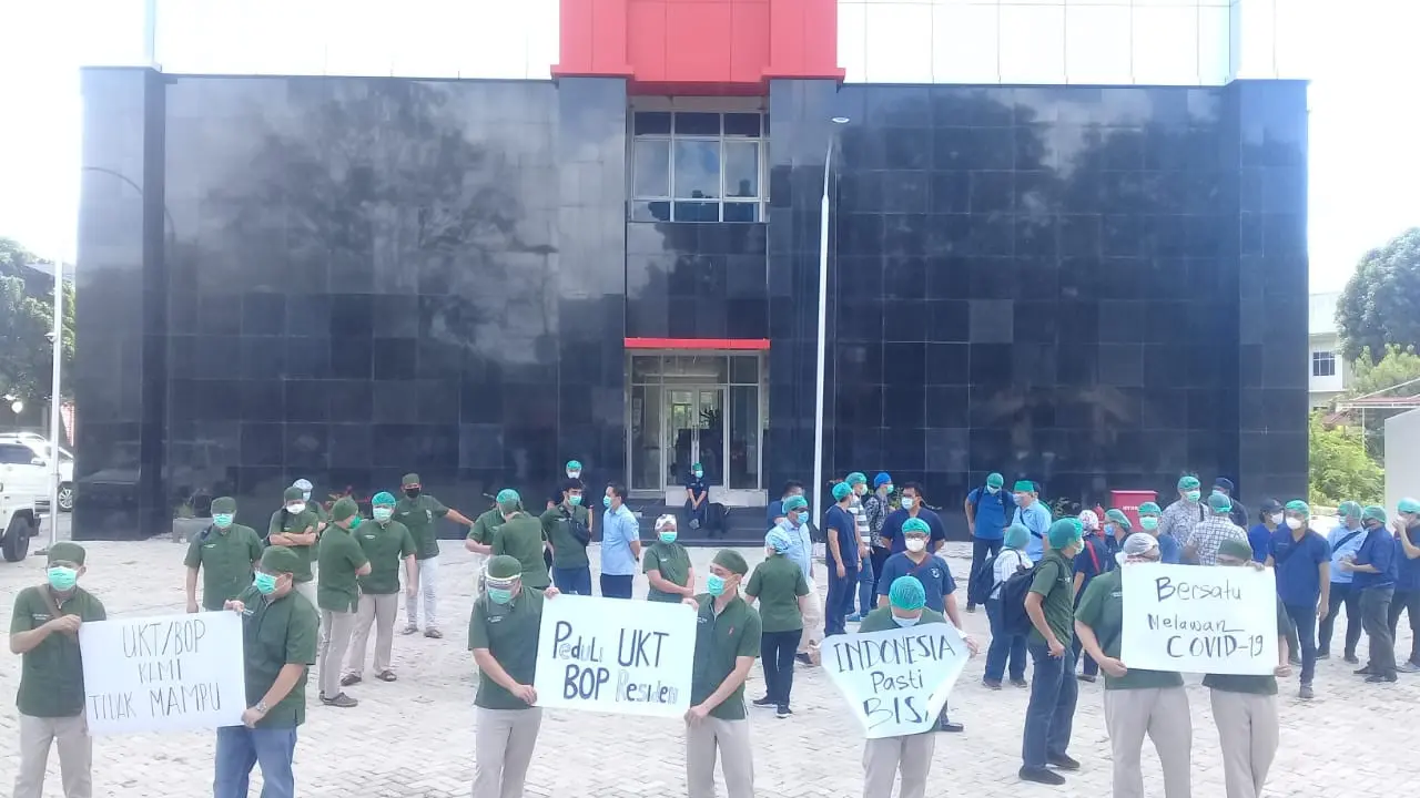 Sejak pukul 13.00 Wita, ratusan dokter residen mulai memadati pintu gerbang kampus Unsrat, di bawah pengawasan ketat satuan pengamanan kampus.