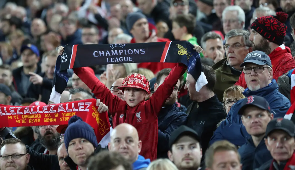Seorang anak membentangkan syal saat mendukung Liverpool  bertanding melawan Red Star Belgrade selama pertandingan grup C Liga Champions di stadion Anfield, Inggris (24/10). Liverpool menang telak 4-0 atas Red Star. (AP Photo/Jon Super)