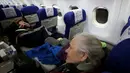 Pengungsi Yahudi Ukraina dan imigran baru dengan kesehatan buruk yang melarikan diri dari perang di negara mereka menunggu untuk turun dari pesawat setibanya di Bandara Ben Gurion, Tel Aviv, Israel, 22 Desember 2022. Sebanyak 100 orang Yahudi Ukraina tiba di Israel, termasuk beberapa penumpang yang terbaring di tempat tidur dan dalam kondisi sakit. (GIL COHEN-MAGEN/AFP)
