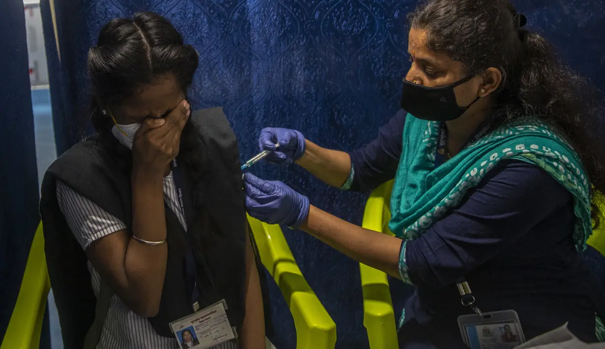 Reaksi gadis sekolah saat disuntik vaksin COVID-19 di pusat vaksinasi di Mumbai, Senin (3/1/2022). India mulai memvaksinasi remaja usia 15 hingga 18 tahun saat banyak negara bagian memberlakukan pembatasan ketat untuk menahan lonjakan infeksi yang dipicu oleh varian omicron. (AP Photo/Rafiq Maqbool)
