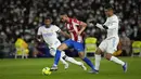 Penyerang Atletico Madrid Matheus Cunha berebut bola dengan pemain Real Madrid David Alaba dan Casemiro pada pekan ke-17 Liga Spanyol di Santiago Bernabeu, Senin dini hari WIB (13/12/2021). Real Madrid berhasil menaklukkan rival sekotanya Atletico Madrid dengan skor 2-0. (AP Photo/Bernat Armangue)