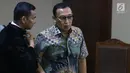 Sekertaris Jenderal Komite Olahraga Nasional Indonesia (KONI) Ending Fuad Hamidy berbincang dengan kuasa hukumnya saat menjalani sidang perdana sebagai terdakwa di Pengadilan Tipikor, Jakarta, Senin (11/3). (Liputan6.com/Johan Tallo)