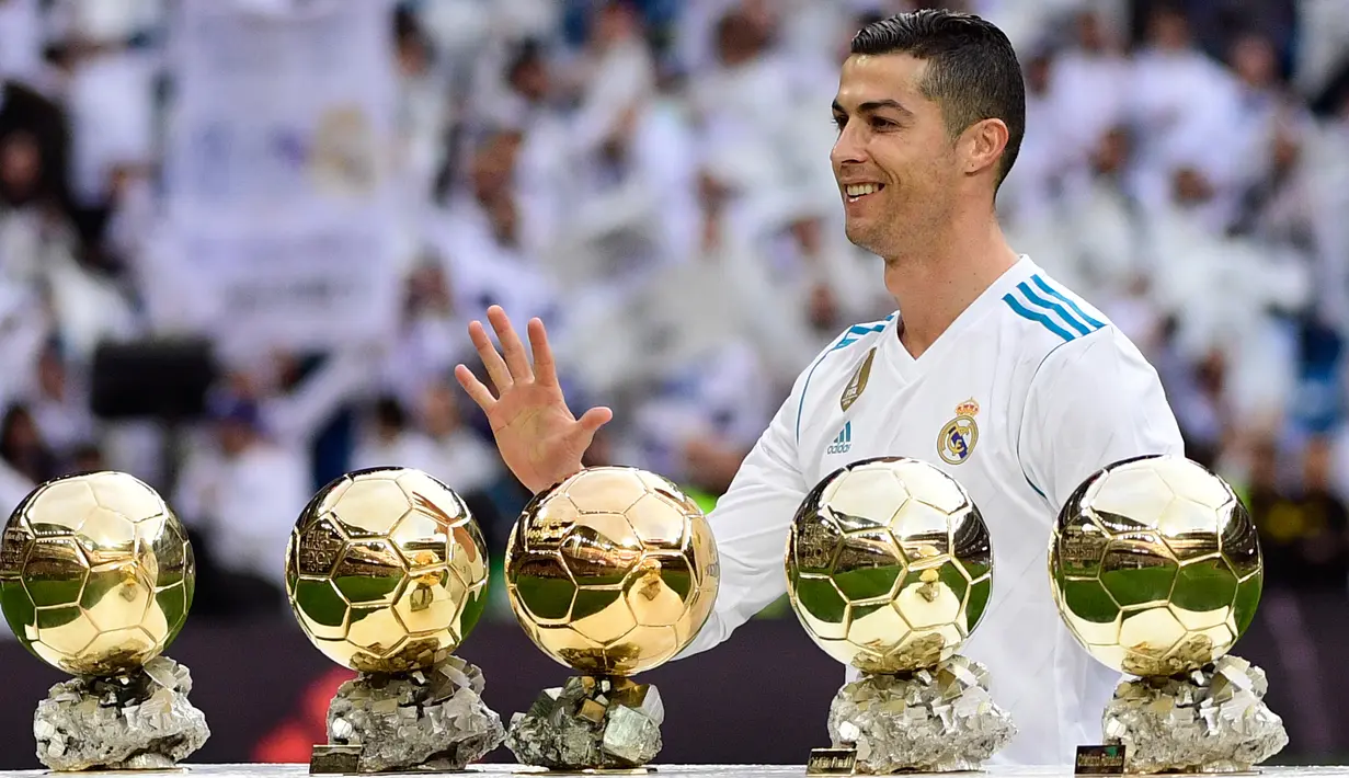 Bintang Real Madrid, Cristiano Ronaldo berpose dengan kelima trofi Ballon d'Or sebelum laga Real Madrid vs Sevilla di Stadion Santiago Bernabeu, Sabtu (9/12). Ronaldo hanya berpose dengan kelima trofi Ballon d'Or seorang diri. (PIERRE-PHILIPPE MARCOU/AFP)