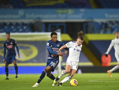 Pemain Arsenal Joe Willock (kiri tengah) berebut bola dengan pemain Leeds United Kalvin Phillips pada pertandingan Liga Premier Inggris di Stadion Elland Road, Leeds, Inggris, Minggu (22/11/2020). Pertandingan berakhir dengan skor 0-0. (Paul Ellis/Pool Via AP)