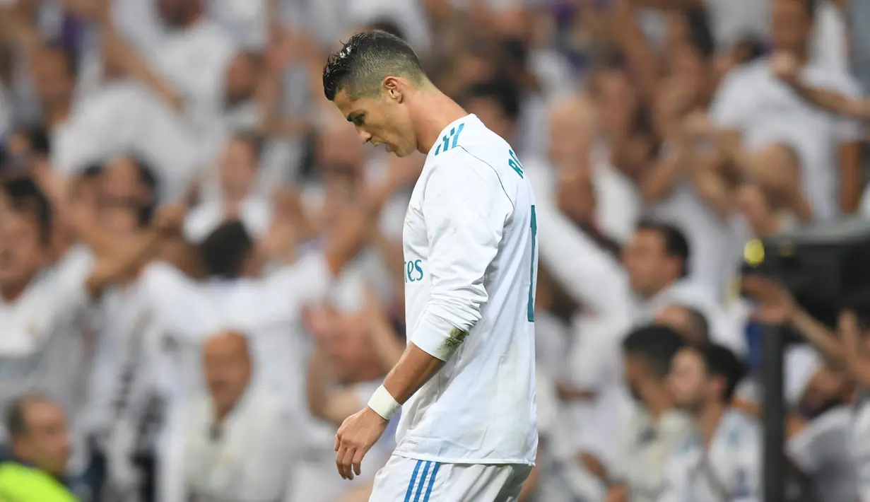 Penyerang Real Madrid, Cristiano Ronaldo tertunduk di lapangan seusai kehilangan satu gol pada laga pekan lima La Liga melawan Real Betis di Santiago Bernabeu, Rabu (20/9). Real Madrid keok 0-1 dari tamunya, Real Betis. (GABRIEL BOUYS/AFP)