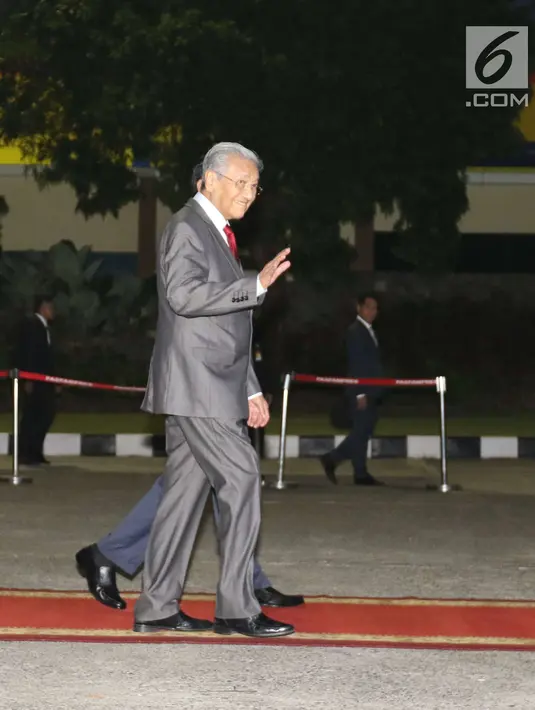 PM Malaysia Mahathir Mohamad menyapa awak media saat tiba di Bandara Halim Perdanakusuma, Jakarta, Kamis (28/6). Pada Jumat, 29 Juni, Mahathir dijadwalkan ke Istana Negara di Bogor untuk menghadiri jamuan makan siang. (Liputan6.com/Angga Yuniar)