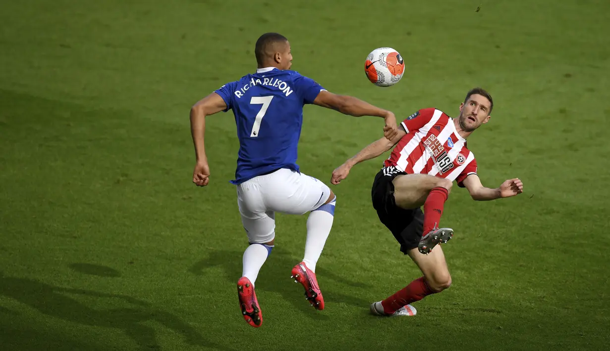 Pemain Everton Richarlison (kiri) berebut bola dengan pemain Sheffield United Chris Basham pada pertandingan Premier League di Bramall Lane, Sheffield, Inggris, Senin (20/7/2020). Everton menang 1-0. (AP Photo/Michael Regan, Pool)