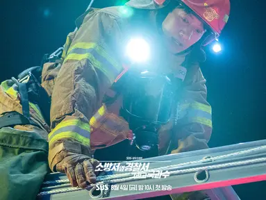 Potongan gambar yang dirilis menunjukkan Jin Ho Gae dan Bong Do Jin bekerja bersama di lokasi kebakaran hanya dengan seutas tali untuk menopang mereka. (Foto: SBS via Soompi)