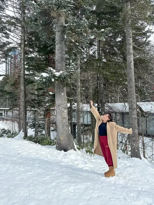 Dalam salah satu potret, Ayu Dewi terlihat memadukan kaus dan celana panjang basic dengan coat panjang yang menjadi elemen kunci dalam tampilannya.