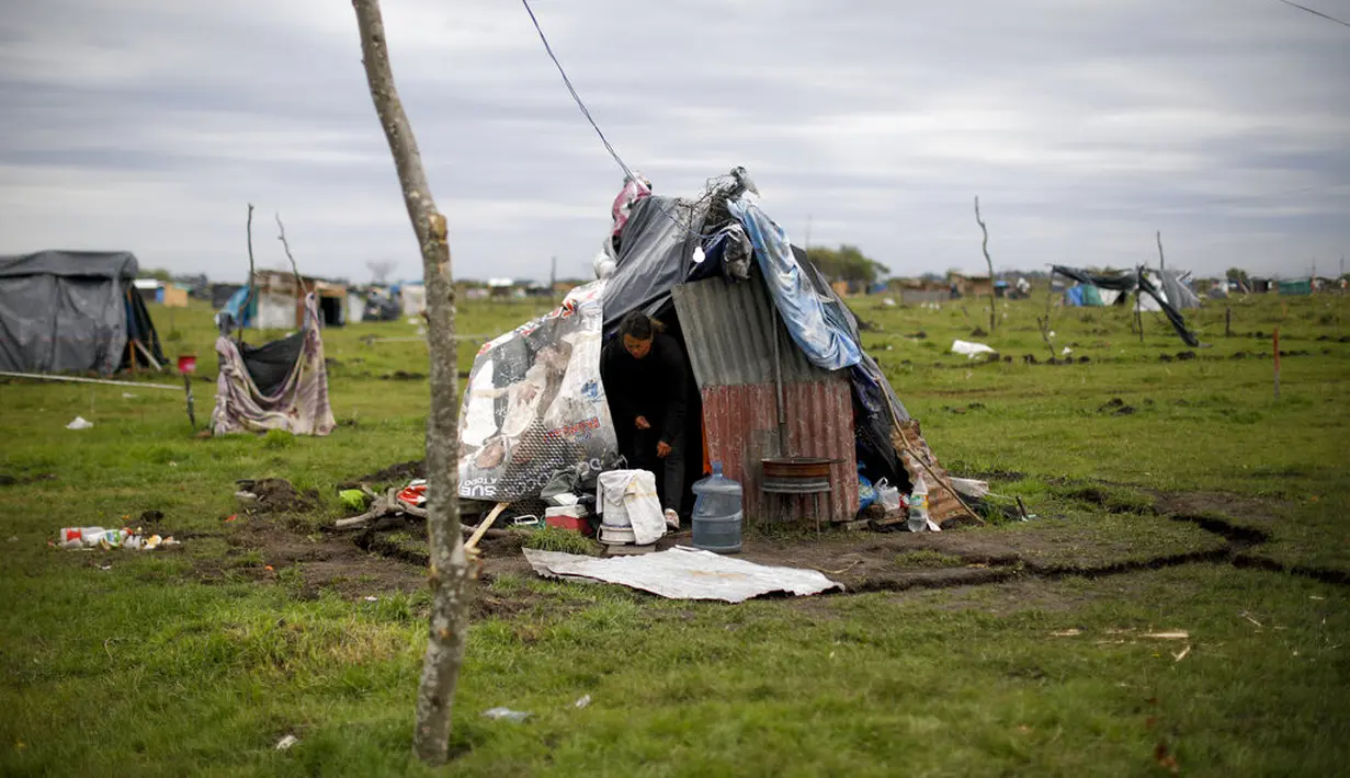 Martina meninggalkan rumah sementara di kamp penghuni liar di Guernica, Provinsi Buenos Aires, Argentina, Kamis (1/10/2020). Pengadilan telah memerintahkan penggusuran, namun penghuni liar mengatakan tidak punya tempat tujuan di tengah pandemi COVID-19. (AP Photo/Natacha Pisarenko)