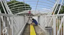 Pekerja menyelesaikan pembangunan jembatan penyebrangan orang di atas sungai Ciliwung di kawasan Manggarai, Jakarta, Senin (4/4). Rencaanya JPO tersebut siap digunakan pada 6 April mendatang. (Liputan6.com/Yoppy Renato)