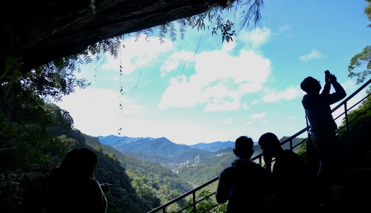 Turis mengambil gambar suasana Kuil Tao  di gua Gunung Yinhe di distrik Xindian, Kota Taipei Baru, Taiwan (29/12/2019). Libur Natal dan Tahun Baru, bagi sebagian warga Taiwan memanfaatkan waktunya untuk berkunjung ke Kuil Tao untuk berwisata maupun memanjatkan doa. (AFP Photo/Sam Yeh)