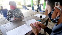 Petugas sedang menyerahkan Bantuan Langsung Tunai Dana Desa (BLT-DD) kepada warga Desa Curug di Kantor Desa Curug, Gunung Sindur, Kabupaten Bogor, Jawa Barat, Kamis (17/09/2020). (merdeka.com/Dwi Narwoko)