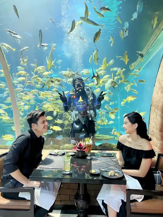 Rendi dan Glenca menyantap berbagai sajian lezat dengan pemandangan ikan-ikan yang berenang. [@glencachysaraofficial]
