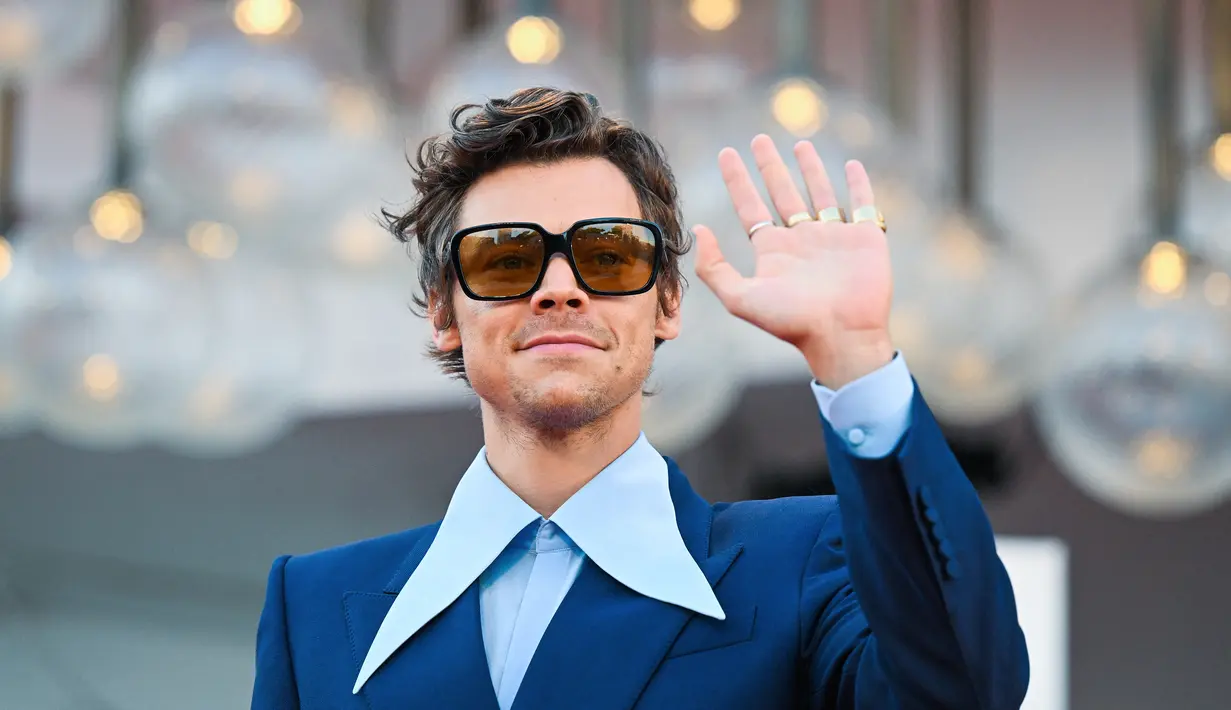 Penyanyi dan aktor Inggris Harry Styles tiba untuk pemutaran perdana film 'Don't Worry Darling' selama Venice Film Festival 2022 di Venesia, Italia, Senin (5/6/2022). Styles tampil dalam balutan jaket royal blue dengan bahu tinggi dan jahitan kotak di sekitar tubuhnya dari koleksi Cruise 2023 Gucci. (Photo by Tiziana FABI / AFP)