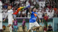 Seorang pria membawa bendera pelangi berlari melintasi lapangan selama pertandingan grup H Piala Dunia 2022 Qatar antara Portugal melawan Uruguay di Stadion Lusail di Lusail, Qatar, Senin, 28 November 2022. Peristiwa pria mengibarkan bendera LGBT itu terjadi pada babak kedua, tepatnya di menit ke-50-an. (AP Photo/Abbie Parr)