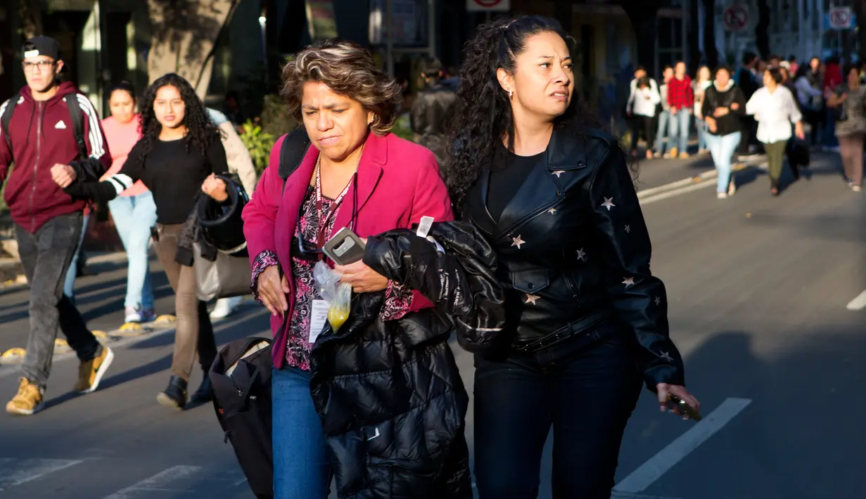 Suasana kepanikan warga saat terjadi gempa di kuat di Mexico City, Meksiko (16/2). Warga setempat yang panik berlarian keluar gedung dan berkumpul di jalanan. (AP Photo / Rebecca Blackwell)