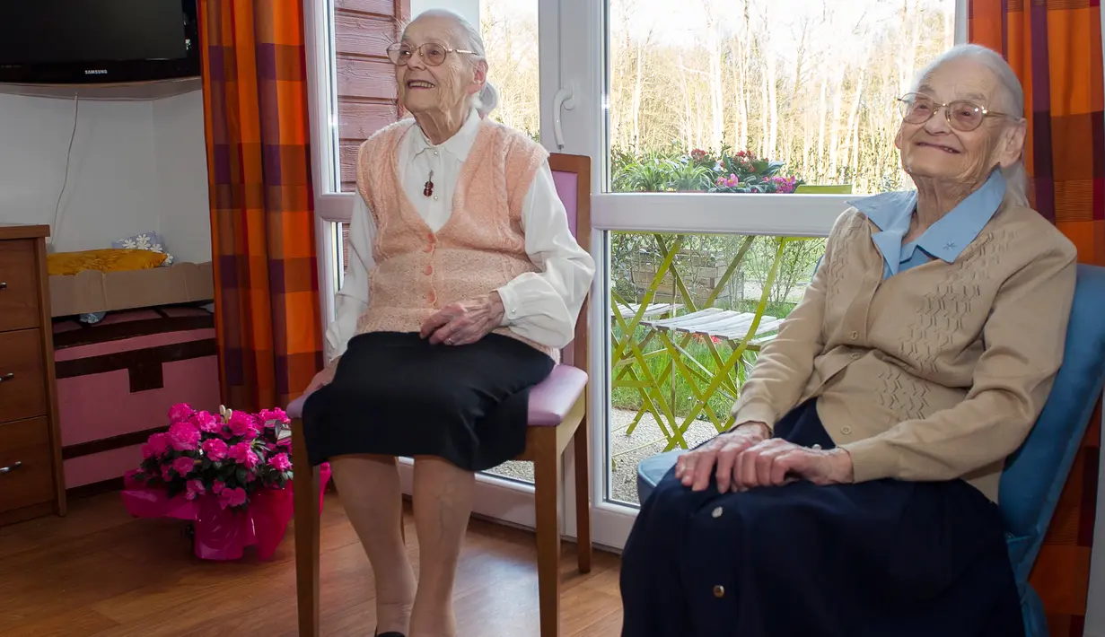 Paulette Olivier (kiri) dan Simone Thiot duduk santai saat berbincang di Ephad "Les Bois Blancs", Prancis (13/2). Paulette dan Simone lahir pada 30 Januari 1912 di Limeray, beberapa kilometer dari Amboise. (AFP PHOTO/GUILLAUME souvent)